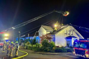 Dachstuhlbrand in Paderborn: Feuerwehr kämpft gegen Flammen und Rauchentwicklung, Einsatzkräfte aktiv.