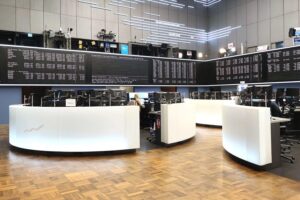 Frankfurter Börse mit Dax-Index, Aktienkurse und wirtschaftlichen Entwicklungen im Hintergrund.