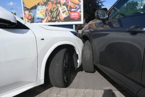 Zwei Autos kollidieren auf einem Parkplatz, während Fahrer unterschiedliche Unfallhergänge schildern.