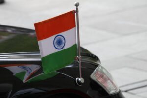 Indische Fahne vor maritimer Kulisse, symbolisiert Trauer um gefallene Seeleute im Konflikt.