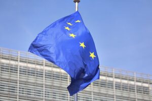 EU-Fahnen vor einem Hintergrund, der Zusammenarbeit zwischen Europa und Afrika symbolisiert.