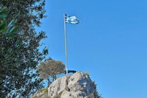 Fahne Griechenlands vor geologischer Karte, Symbol für Erdbebenereignis und nationale Identität.
