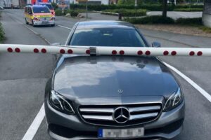 Bahnübergang mit gesenkter Schranke und beschädigtem Fahrzeug nach Verkehrsunfall in Lippstadt.