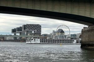 Festgefahrenes Fahrgastkabinenschiff auf dem Rhein, Bergungsaktion durch Polizei im Hintergrund.