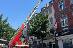 Einsatzkräfte sichern beschädigte Fassade eines Wohnhauses in Witten mit Feuerwehr und THW.