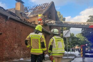 Feuerwehr im Einsatz, löschende Flammen und beschädigtes Wohngebäude in Grevenbroichs Stadtteil Elsen.