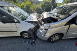 Zwei beschädigte Fahrzeuge nach Verkehrsunfall auf Bundesstraße, Einsatz von Rettungsdiensten sichtbar.