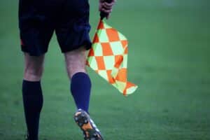 Linienrichter mit Fahne im Fußball, Symbol für spannendes 1:1 zwischen Saudi-Arabien und Uruguay.