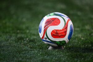 Spielball der WM 2026, umgeben von Fußball-Atmosphäre und Emotionen einer spannenden Partie.