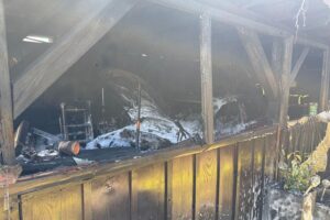 Feuerwehr löscht Garagenbrand, verhindert Übergreifen auf Wohnhaus, zahlreiche Einsatzkräfte vor Ort.
