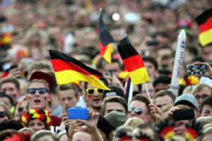 Fußballfans feiern vor dem Fernseher, trotz geringer wirtschaftlicher Auswirkungen der WM 2026.