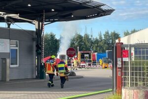 Feuerwehr und Rettungsdienst bekämpfen Rauchentwicklung und Flammen an einer Wechselbrücke.