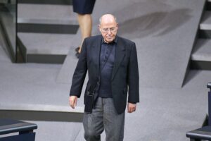 Gregor Gysi spricht auf einer Bühne, umgeben von Publikum, und verteidigt seine Nebeneinkünfte.