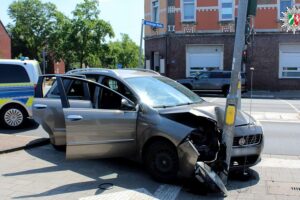 Ein beschädigtes Auto stößt gegen eine Ampel, Unfallursache Hitzeillusion.