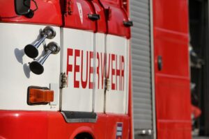 Feuerwehr löscht Kellerbrand, Rauch dringt aus Lichtschächten, mehrere Bewohner gerettet.