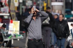 Mann nutzt Smartphone in einem öffentlichen Bereich mit WLAN-Zugang in Bernburg.