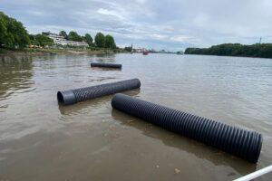 Kunststoffrohre treiben gefährlich im Rhein nach Starkregen, Feuerwehr und Polizei im Einsatz.