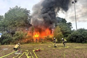 Vollbrand eines leerstehenden Vereinsheims, Feuerwehr im Einsatz, dichte Rauchentwicklung, Einsatzkräfte kämpfen gegen Flammen.