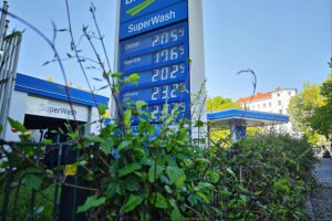 Tankstelle mit Zapfsäulen, Kunden tanken, Preisanzeige, Hinweise zur Steuersenkung.