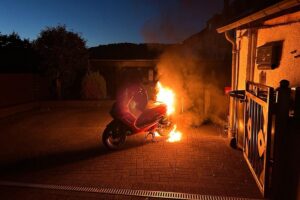 Brand eines Motorrollers in der Nacht; Feuerwehr im Einsatz, kein Gebäudeschaden, keine Verletzten.