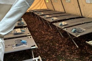 Notunterkunft für Obdachlose in Frankfurt: Zelte, Feldbetten, humanitäre Unterstützung durch Feuerwehr.