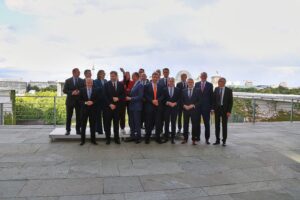 Ein Bild von Verhandlungstisch mit Politikern, Gewerkschaften und Arbeitgebervertretern in konstruktiver Diskussion.