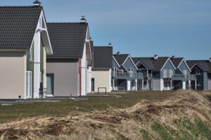 Ein modernes Neubaugebiet mit Wohnhäusern und Grünflächen in urbaner Umgebung.