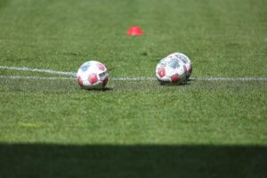 Fußbälle symbolisieren die Verbindung zwischen Fußball und gesellschaftlicher Stimmung während politischer Reformen.
