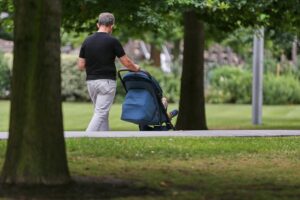 Vater mit Kind, symbolisiert starke Vaterschaft und partnerschaftliche Elternzeit.