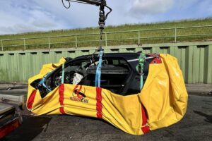 Ein schwer beschädigtes Elektroauto nach einem Unfall mit einem Lastwagen im Fischereihafen.
