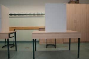 Wahllokal mit Wählern, Wahlurnen und Wahlzetteln während der Landratswahl in Saalfeld-Rudolstadt.