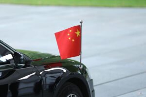 Chinesische Fahne vor einem Hintergrund, der Zusammenarbeit und wissenschaftliche Integrität symbolisiert.