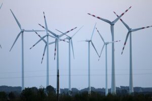 Windräder vor blauem Himmel, symbolisieren Deutschlands steigende Stromproduktion aus erneuerbaren Energien.