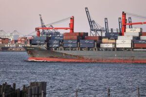 Industrieanlagen im Hintergrund, reflektieren Risiken und Resilienz der deutschen Produktionsindustrie.