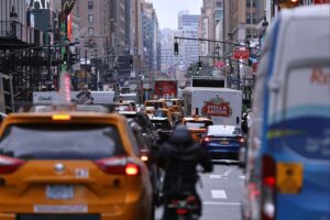 New Yorker Straßenverkehr, Menschen und Autos, symbolisiert das urbane Leben in den USA.
