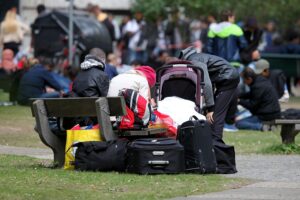 Flüchtlinge an einer deutschen Aufnahmestelle, darunter Männer und Frauen unterschiedlicher Herkunft.