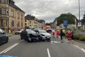 Zwei beschädigte Autos an einer Kreuzung, Polizei regelt den Verkehr nach Unfall.