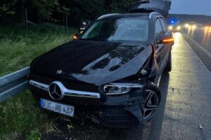 Beschädigter Mercedes nach Unfall auf nasser Fahrbahn, flüchtiger Audi-Fahrer, Polizei sucht Zeugen.