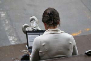 Frau mit Laptop, symbolisiert digitale Transformation und den Einsatz von Künstlicher Intelligenz in Unternehmen.