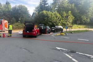 Unfallstelle mit mehreren PKW, Rettungsdiensten und Feuerwehr im Einsatz. Verletzte Personen werden versorgt.