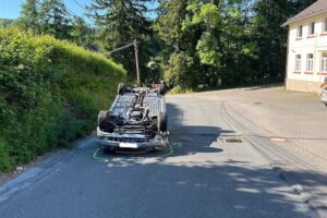Ein verunfallter Mercedes liegt auf dem Dach an einer Straße (Archivfoto), Polizei Oberbergischer Kreis.
