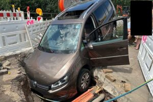 Unfallort mit verunfalltem PKW, Baustelle und Rettungsarbeiten, Personen sicher.