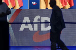 AfD-Logo vor einem Hintergrund von östdeutschen Landkarten und politischen Symbolen.