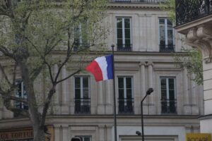 Marine Le Pen vor Gericht mit französischer Fahne, symbolisiert politische Herausforderungen und Ämtersperren.