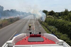 Flächenbrand an A57, Feuerwehr im Einsatz, starke Rauchentwicklung, Verkehrsbehinderungen, Löschfahrzeuge.