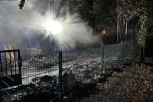 Feuerwehr im Einsatz an der Gesamtschule Schermbeck: Mülltonnen in Vollbrand, gelöscht mit C-Rohren.