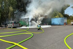 Feuerwehr löscht Brand zweier Überseecontainer in Bochum-Wattenscheid, starke Rauchentwicklung über der Lohrheidestraße.