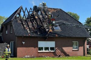 Feuerwehr am Einfamilienhaus: Dachstuhlbrand in Geestland, Haus unbewohnbar, Einsatzkräfte löschen und sichern.