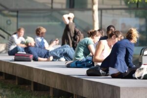 Junge Studierende vor einer Universität: hohe Wohnkostenbelastung und geringeres Einkommen in Deutschland.