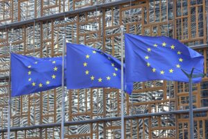 EU-Fahnen in Brüssel: EU-Kommission reformiert Emissionshandel, um höhere CO₂-Emissionen zu ermöglichen, Ausbau der Speicherung geplant.